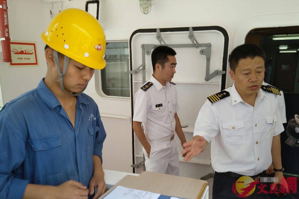 「育鯤」輪船長劉新卓(右)介紹市民登船參觀程序